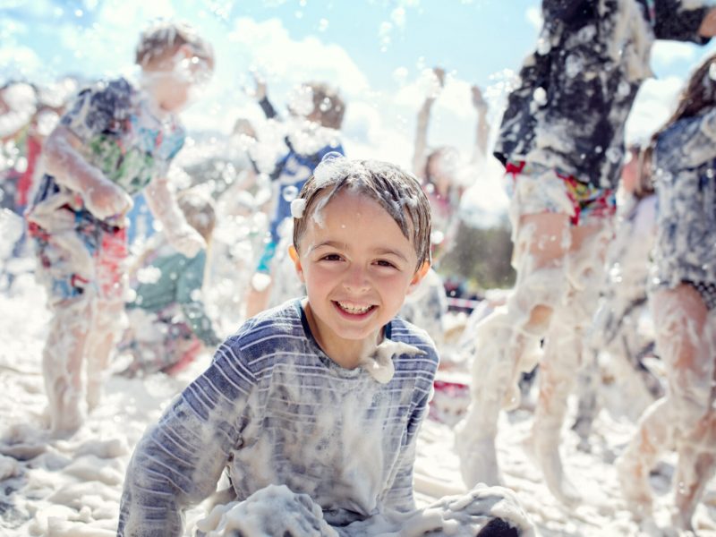 Boy,Smiling,And,Laughing,Covered,In,Soap,Suds,At,A